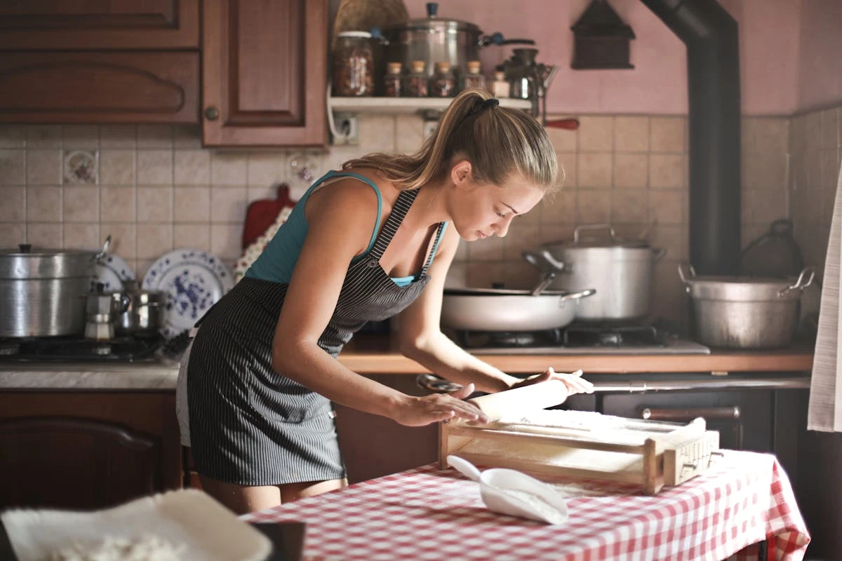 Hands shaping dough on a floured surface