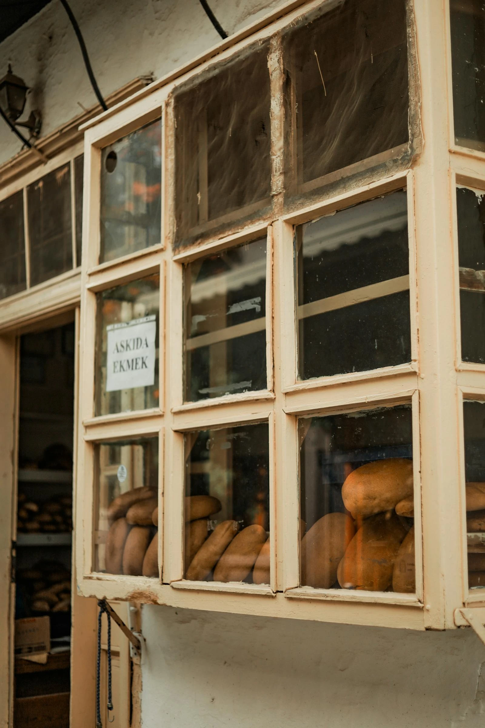 Warm sunlit bakery interior with fresh bread on wooden surfaces